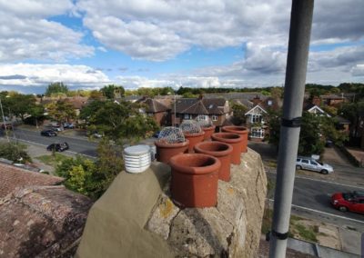 Rooftop chimney with multiple terracotta pots. Cambridge Roofing Repairs