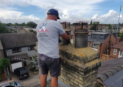 Roofing professional inspecting a chimney with newly installed chimney caps
