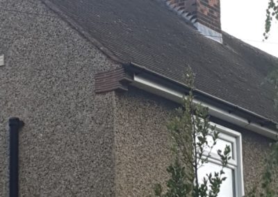 Brick chimney with chimney cowls on a sloped roof of a residential building